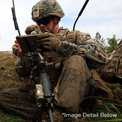 Marine sitting with rifle in carry position, front mount of sling uses Rail Mounted Fixed Loop hardware to firearm rail